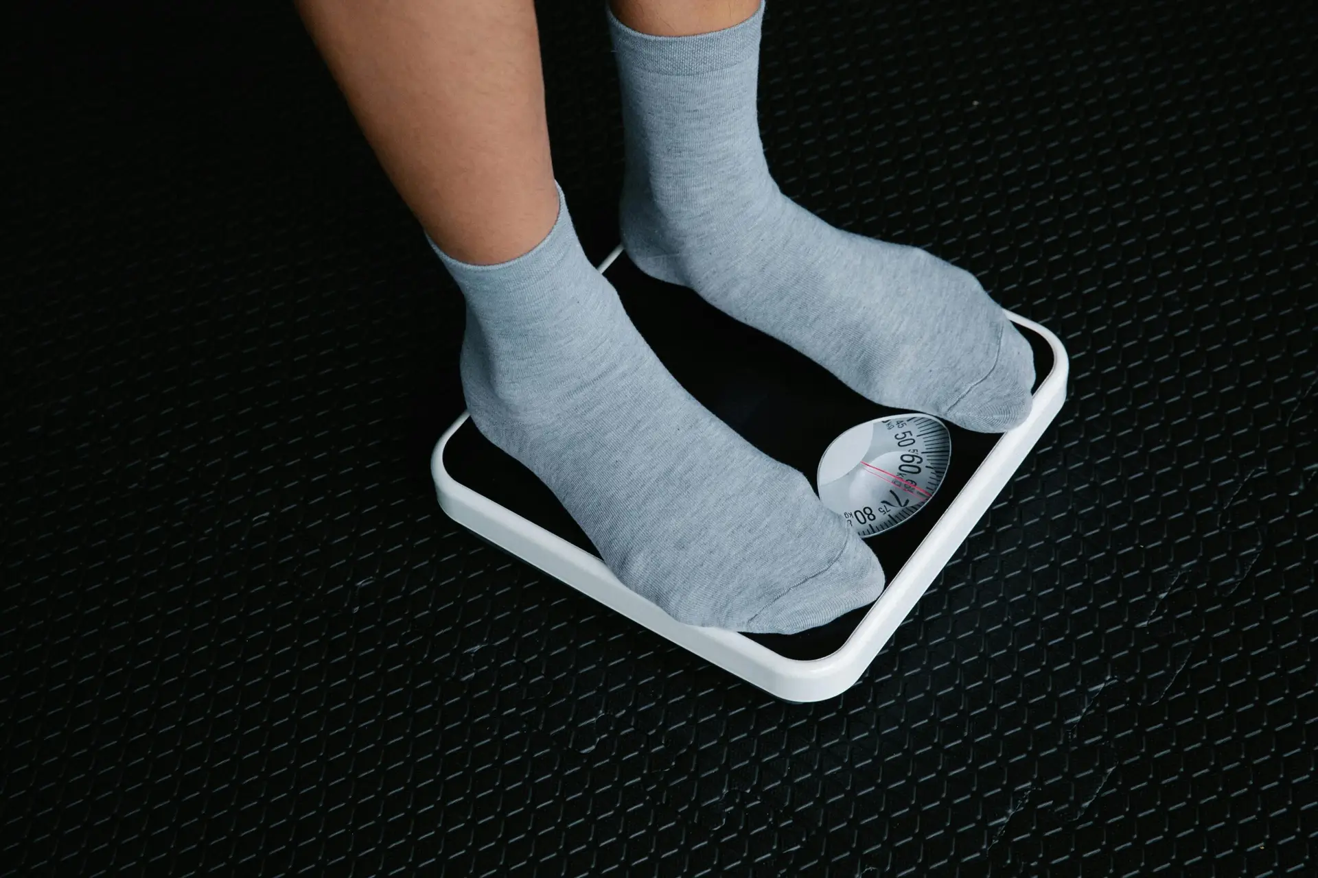 feet of a man in stockings standing on a weighing scale